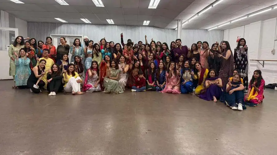 The whole school in traditional dress at rehearsal