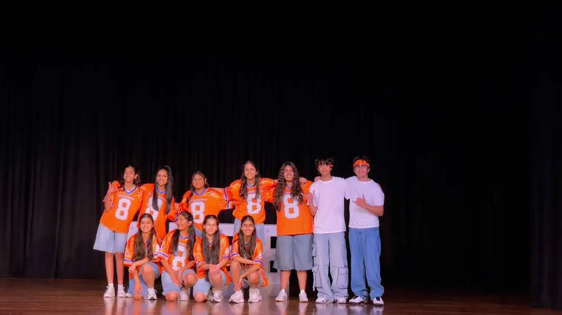 Teens on stage in orange jerseys